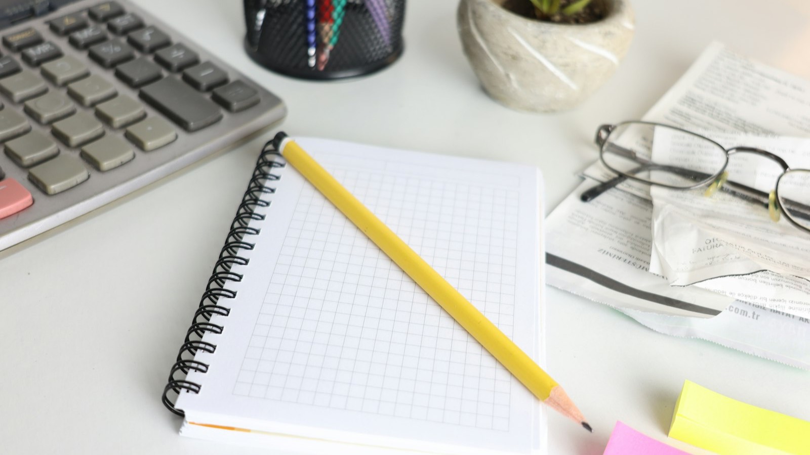 Bureau met rekenmachine, notitieblok en bonnetjes voor de administratie